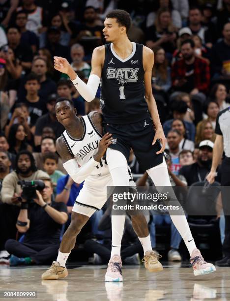 Dennis Schroder of the Brooklyn Nets guards Victor Wembanyama of the San Antonio Spurs in the second half at Moody Center on March 17, 2024 in San...