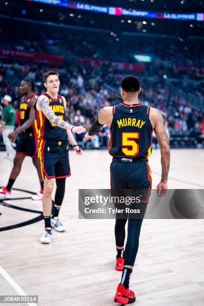 Dejounte Murray greets Vit Krejci of the Atlanta Hawks during the game against the LA Clippers on March 17, 2024 at Crypto.Com Arena in Los Angeles,...