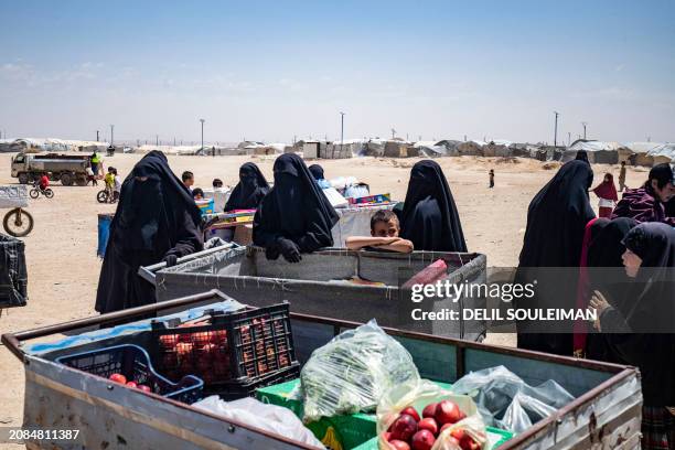 Women and children gather around carts at the al-Hol camp in Syria's northeastern Al-Hasakah Governorate, on October 10, 2023. The al-Hol camp is the...