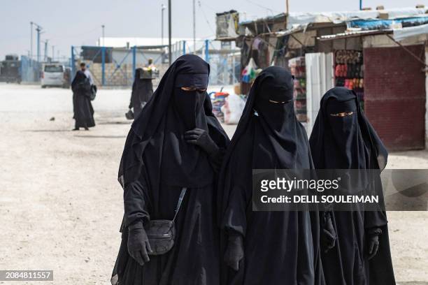 Women walk past stalls at the al-Hol camp in Syria's northeastern Al-Hasakah Governorate, on October 10, 2023. The al-Hol camp is the largest of two...
