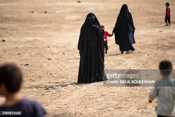 Women walk through the al-Hol camp in Syria's northeastern Al-Hasakah Governorate, on October 11, 2023. The al-Hol camp is the largest of two in...