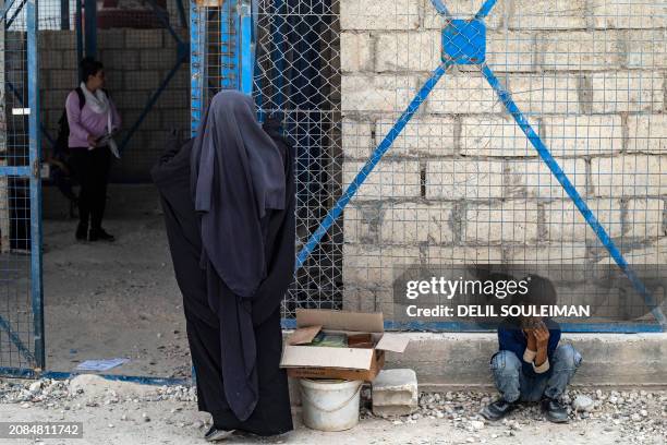 Woman stands at a gate of the al-Hol camp in Syria's northeastern Al-Hasakah Governorate, on October 10, 2023. The al-Hol camp is the largest of two...