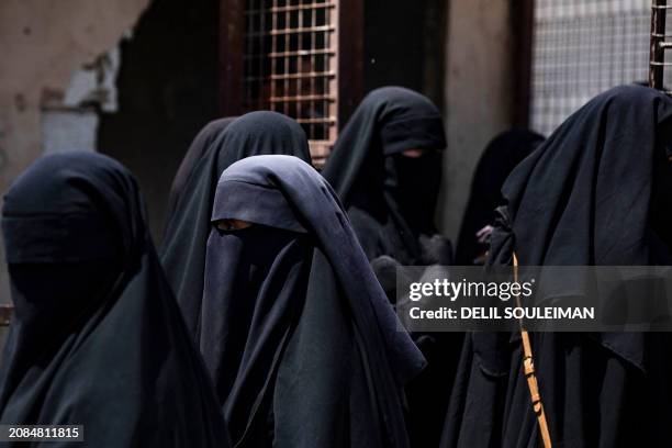 Women stand next to a fence at the al-Hol camp in Syria's northeastern Al-Hasakah Governorate, on October 10, 2023. The al-Hol camp is the largest of...