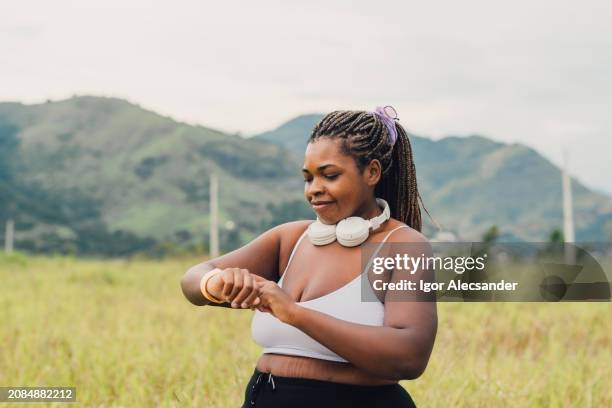 plus size woman setting up smartwatch for outdoor walk - spaghetti straps stock pictures, royalty-free photos & images