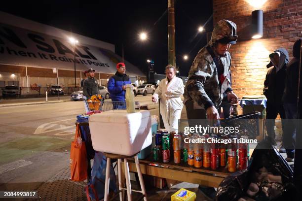 Venezuelan migrant Rengi Jesus Faltime restocks soda cans while selling the drinks and candy outside a migrant shelter on North Elston Avenue across...