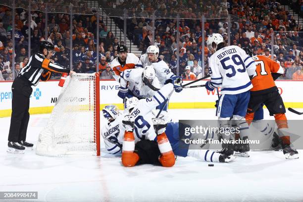 Toronto Maple Leafs and Philadelphia Flyers players challenge for the puck during the second period at the Wells Fargo Center on March 14, 2024 in...