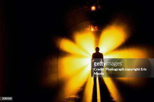 silhouette of man in tunnel with lights - aura foto e immagini stock