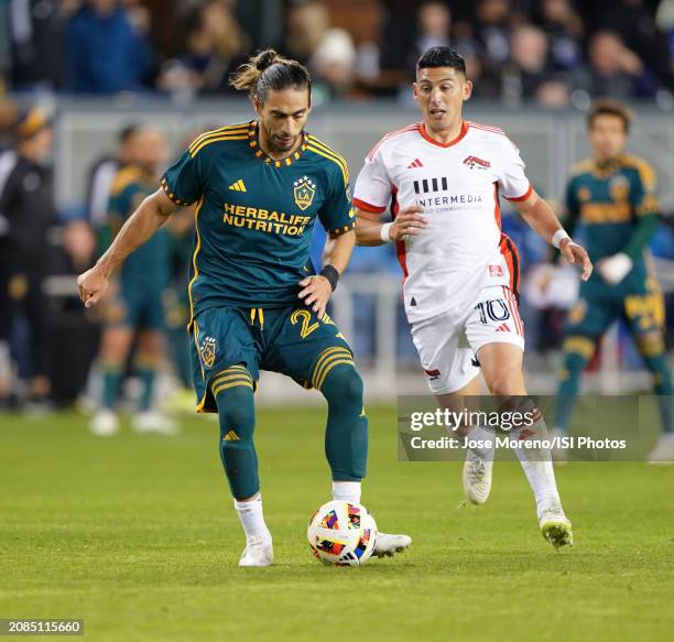 Galaxy defender Martín Cáceres controls the ball from San Jose Earthquakes forward Cristian Espinoza in the midfield during a game between Los...