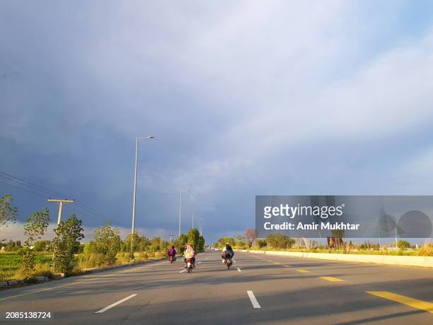 dramatic gray clouds and sunlight on multilane motorway. travelling on multiple lanes highway crossing through non-urban area. - non motorised vehicle stock pictures, royalty-free photos & images