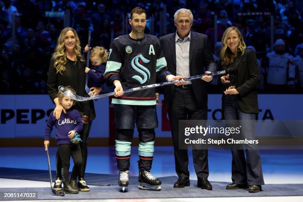 Jordan Eberle of the Seattle Kraken is presented a silver hockey stick to commemorate his 1,000th NHL game by general manager Ron Francis and...