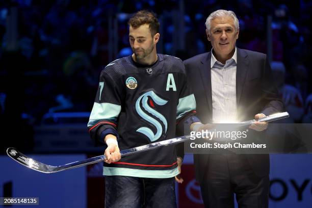 Jordan Eberle of the Seattle Kraken is presented a silver hockey stick to commemorate his 1,000th NHL game by general manager Ron Francis before the...