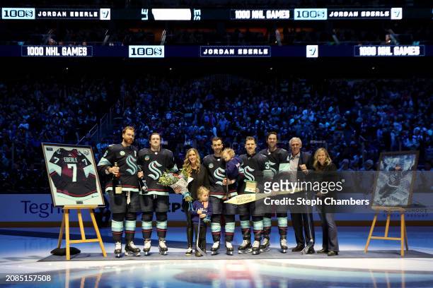 Jordan Eberle of the Seattle Kraken is presented a silver hockey stick to commemorate his 1,000th NHL game by general manager Ron Francis and...