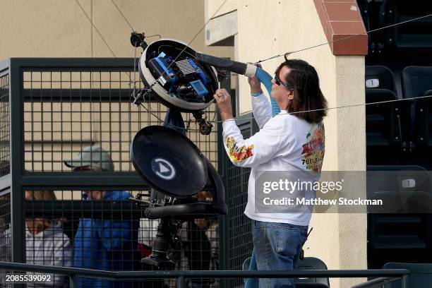 Beekeeper Lance Davis removes bees from a Spider Cam as play is suspended between Carlos Alcaraz of Spain and Alexander Zverev of Germany during the...