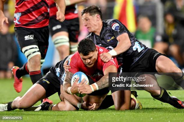 Levi Aumua of the Crusaders is tackled by Cam Roigard of the Hurricanes during the round four Super Rugby Pacific match between Crusaders and...