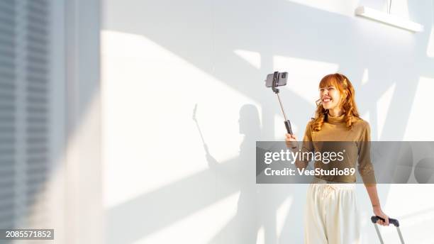 asian woman using smartphone in airport terminal. - influencer stock pictures, royalty-free photos & images