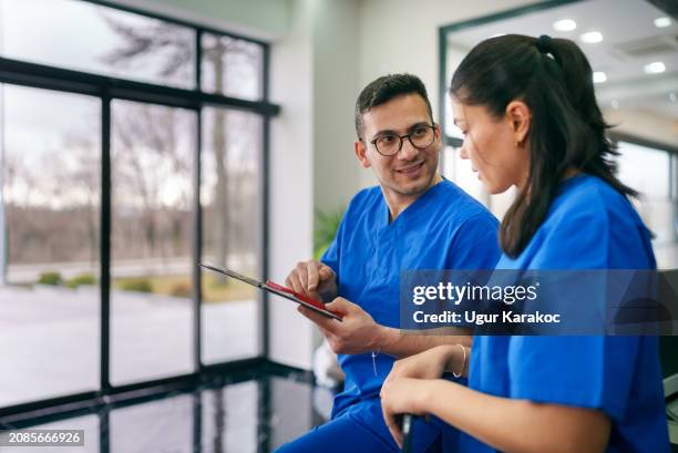 healthcare workers talking together at the lobby in the clinic. - dental office staff stock pictures, royalty-free photos & images