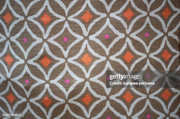 a patterned cloth with a brown and white background and orange and pink dots - argyle stock pictures, royalty-free photos & images