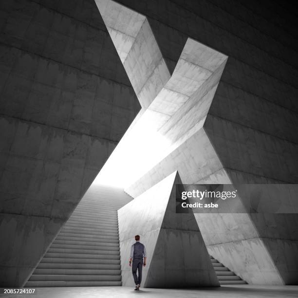 a man entering a hall with stairs through x shaped gate - letra x imagens e fotografias de stock