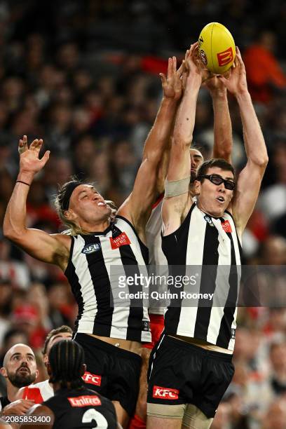 Darcy Moore and Mason Cox of the Magpies compete for the ball against Brodie Grundy of the Swans during the round one AFL match between Collingwood...