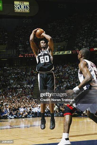 David Robinson of the San Antonio Spurs shoots over Dikembe Mutombo of the New Jersey Nets in Game three of the 2003 NBA Finals at Continental...