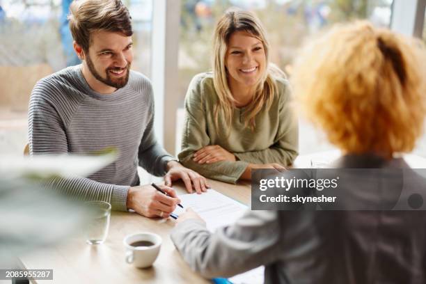 glückliches paar im gespräch mit ihrem finanzberater im büro. - unterschreiben stock-fotos und bilder