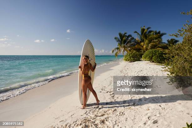 young female surfer walking on the beach. - meeru island stockfoto's en -beelden