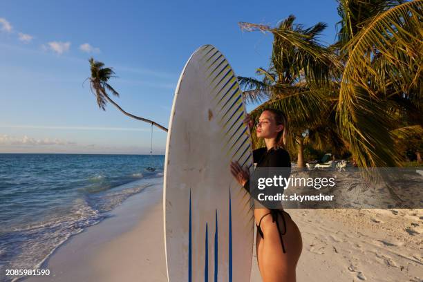 young female surfer day dreaming in summer day on the beach. - meeru island stockfoto's en -beelden