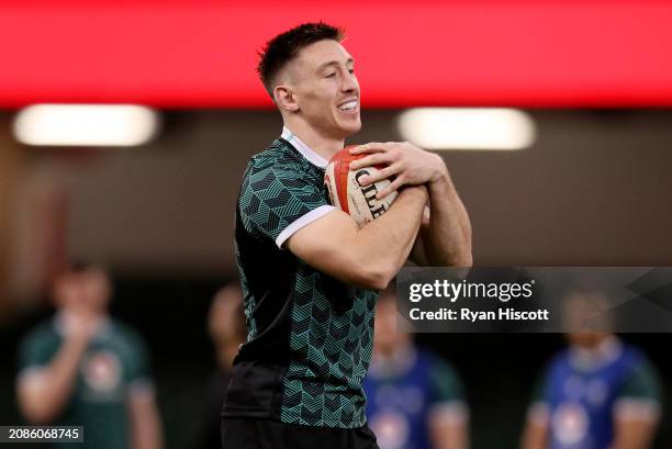 Josh Adams of Wales reacts as he catches a ball during the Wales Captain's Run, prior to the Guinness Six Nations Round Five match between Wales and...