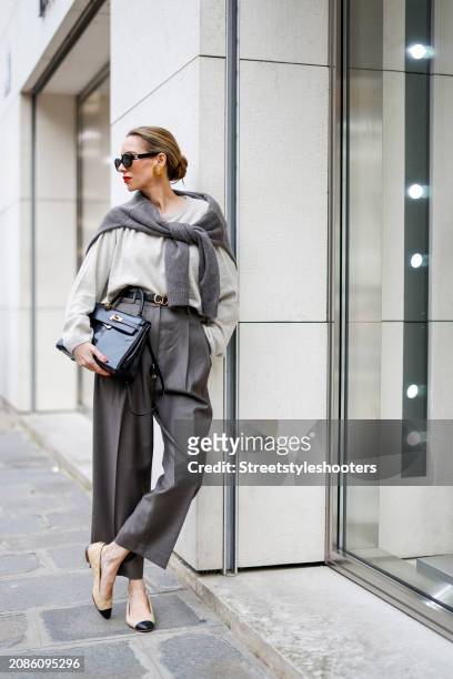 Alexandra Lapp is seen wearing a H&M cashmere jumper in light grey, a H&M cashmere sweater in dark grey, Toteme pants in taupe, a Christian Dior belt...