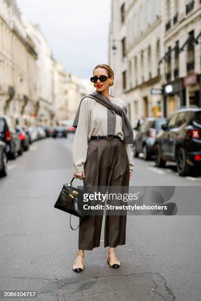 Alexandra Lapp is seen wearing a H&M cashmere jumper in light grey, a H&M cashmere sweater in dark grey, Toteme pants in taupe, a Christian Dior belt...