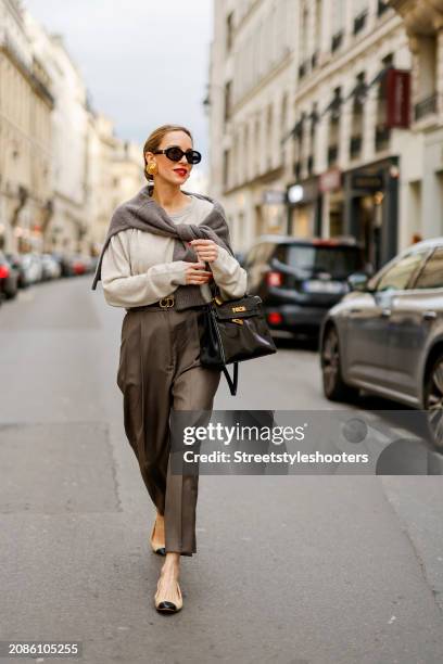 Alexandra Lapp is seen wearing a H&M cashmere jumper in light grey, a H&M cashmere sweater in dark grey, Toteme pants in taupe, a Christian Dior belt...