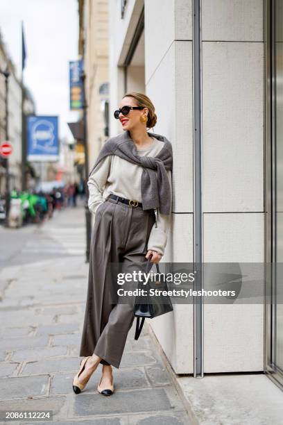 Alexandra Lapp is seen wearing a H&M cashmere jumper in light grey, a H&M cashmere sweater in dark grey, Toteme pants in taupe, a Christian Dior belt...