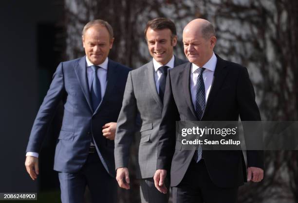 Polish Prime Minister Donald Tusk, French President Emmanuel Macron and German Chancellor Olaf Scholz prepare to review a guard of honour at the...