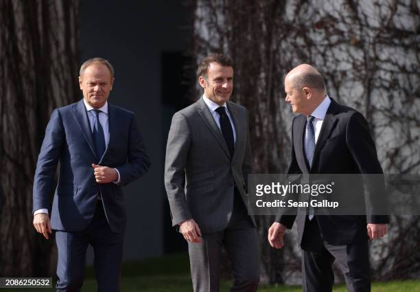 Polish Prime Minister Donald Tusk, French President Emmanuel Macron and German Chancellor Olaf Scholz prepare to review a guard of honour at the...