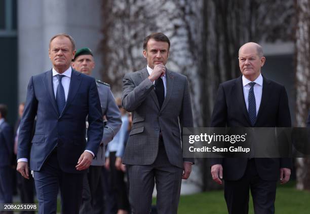 Polish Prime Minister Donald Tusk, French President Emmanuel Macron and German Chancellor Olaf Scholz review a guard of honour at the Chancellery...