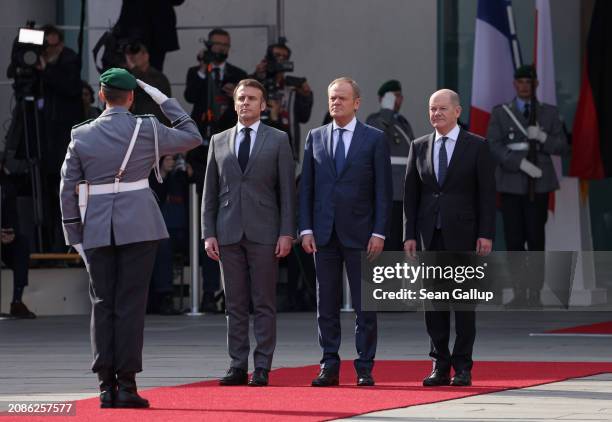 French President Emmanuel Macron, Polish Prime Minister Donald Tusk and German Chancellor Olaf Scholz review a guard of honour at the Chancellery...