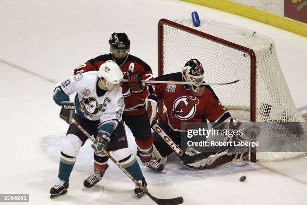 Martin Brodeur of the New Jersey Devils looks to make a save on Paul Kariya of the Mighty Ducks of Anaheim as Scott Niedermayer helps defend in game...