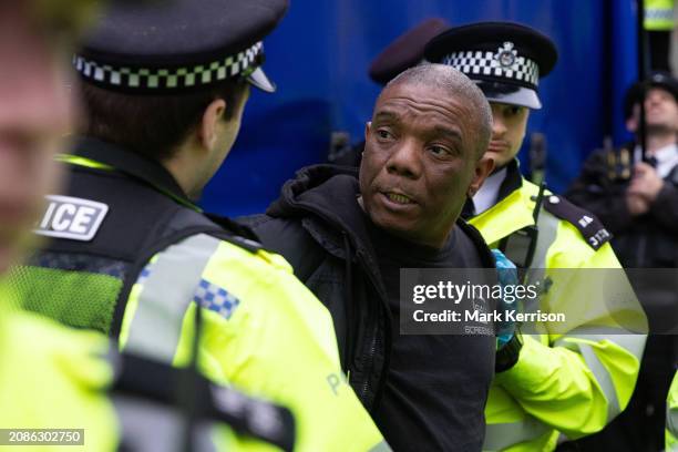 Metropolitan Police officers arrest a man as they close down a sound system being used for a House Against Hate anti-racism event outside Downing...