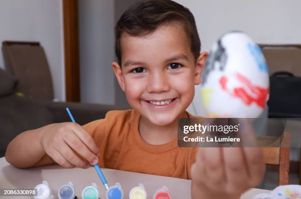 boy painting eggs for easter - hand painted easter eggs stock pictures, royalty-free photos & images
