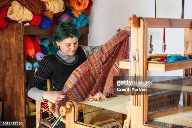 artisane tisserande tissant sur un métier à tisser traditionnel en bois dans son atelier - tisser photos et images de collection