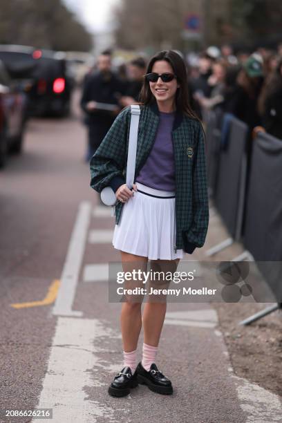 Nina Urgell Cloquell seen wearing a white tennis skirt, green and black checkered Lacoste jacket, purple shirt, black shades, black leather loafer,...