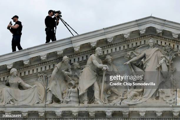 Members of the U.S. Secret Service Counter-Sniper team set up watch from the roof of the House of Representatives as President Joe Biden arrives at...