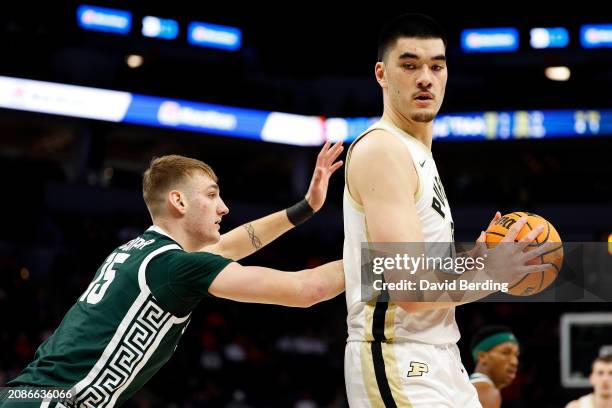 Zach Edey of the Purdue Boilermakers handles the ball against Carson Cooper of the Michigan State Spartans in the first half at Target Center in the...