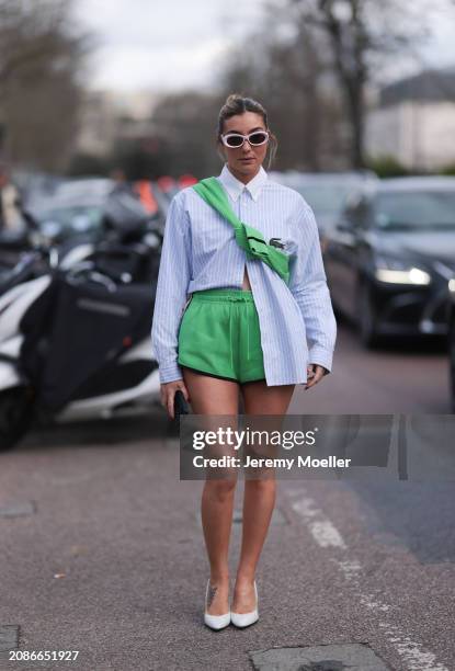 Mariana Machado seen wearing a Lacoste babyblue blouse, green shorts, green pullover and white heels and shades outside Lacoste Show during the...