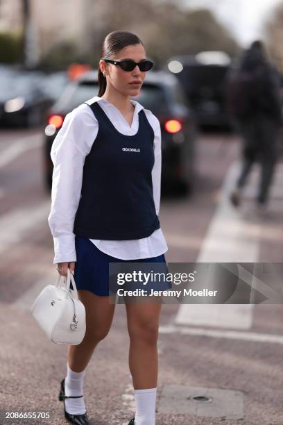 Catarina Pereira Nogueria seen wearing a blue sweater vest, white blouse, blue matching skirt, high white socks, black sandals and shades and a white...