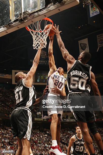 Kerry Kittles of the New Jersey Nets goes to the basket against Tim Duncan and David Robinson of the San Antonio Spurs in Game three of the 2003 NBA...