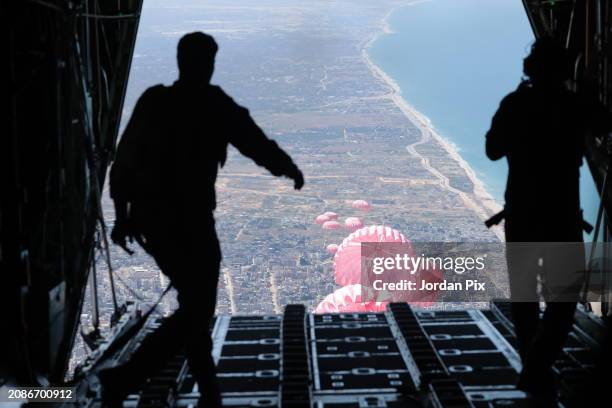 Jordanian Armed Forces personnel carry out an airdrop on March 15, 2024 over northern Gaza. Expensive Airdrops are considered inefficient by the aid...