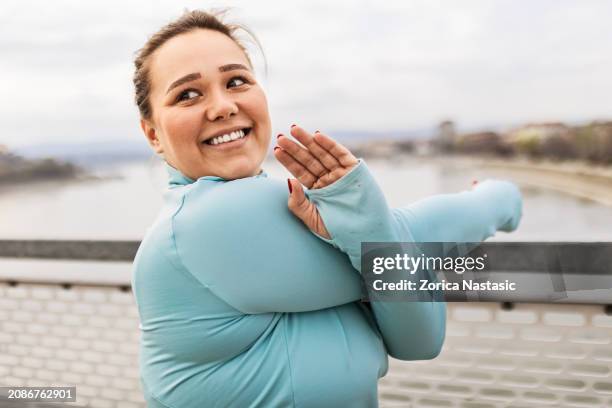 overweight woman stretching - afvallen stockfoto's en -beelden