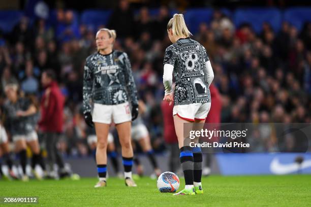 Arsenal players warm up with black and blue socks after being forced to change colour socks which results in a delayed kick off time prior to the...