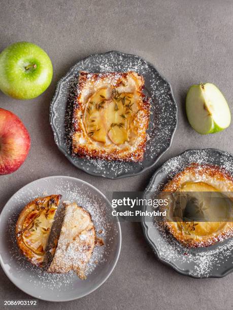 apple pie with sugar powder. apple pie. puff pastry dessert on background. breakfast pastries. puff pastry pie with apple and thyme. puff pastry pies filled with caramelized apples. open pies of puff pastry pies with apple and castor sugar. - apple tart stock pictures, royalty-free photos & images